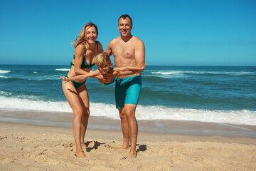 Family enjoying fun beach time together, play airplane with kid
