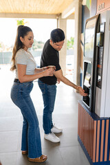 Couple grabbing a coffee from a vending machine