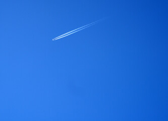 Sharp telephoto close-up of jet plane aircraft with contrails 
