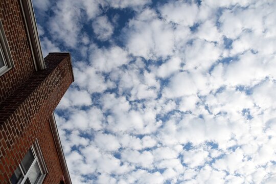 Altocumulus clouds against a blue sky with brick building