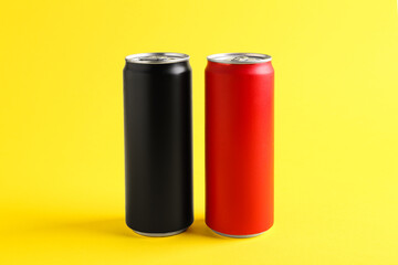 Energy drinks in colorful cans on yellow background