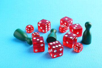 Many red dices and color game pieces on light blue background