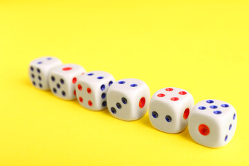 Many white game dices on yellow background, closeup