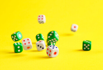 Many color game dices falling on yellow background