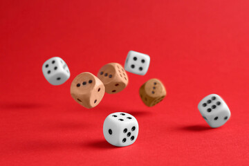 Many color game dices falling on red background