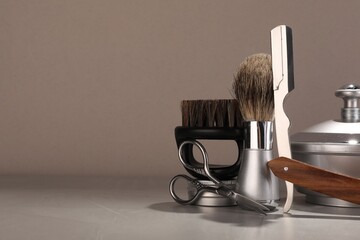 Moustache and beard styling tools on grey table. Space for text