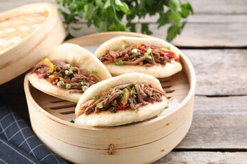 Delicious gua bao in bamboo steamer on wooden table