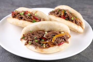 Delicious gua bao in plate on grey table, closeup