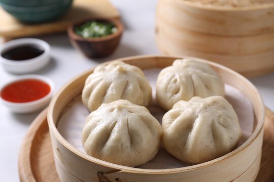 Delicious bao buns (baozi) on light table, closeup