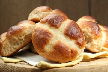 Tasty hot cross buns on wooden table, closeup