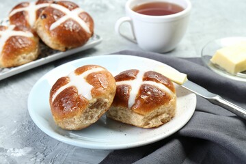 Tasty hot cross buns served on gray textured table, closeup