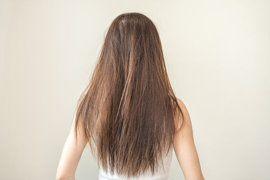 Damaged hair, frustrated asian young woman, girl in splitting ends, messy unbrushed dry hair and frizzy with long disheveled hair, health care of beauty. Portrait isolated on background, Back view.
