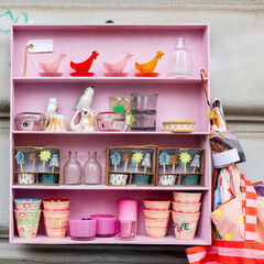 Various souvenirs decorating the house in a pink collecting cabinet - bottles, sculptures, vases,...