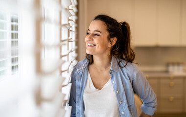 Portrait of a beautiful young woman standing in the kitchen at home
