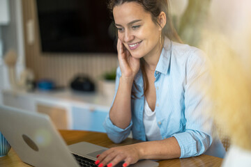 Portrait of smiling woman working on laptop at home

