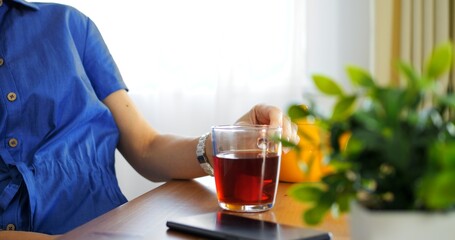 Pouring black Indian tea close-up, vibrant yellow teapot, cozy ambiance. Cinematic tea moment...