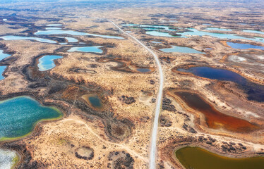 The road among of hundreds of small steppe multi-colored lakes in the delta of the Topar River, a...