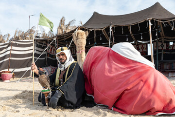 Bedouin with his camel resting in the desert