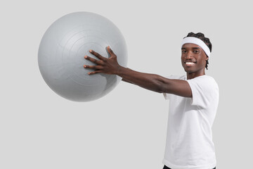 Athletic man posing with exercise ball on white background