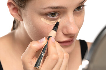 Woman  applying concealer on flawless fresh skin, doing make up. Girl  put corrector under eye area.