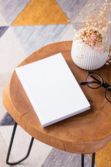 blank book mockup on coffee table with decoration flowers and colorful rug