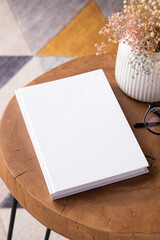 blank book mockup on coffee table with decoration flowers and colorful rug