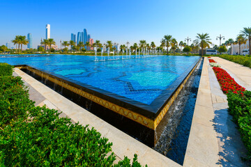 View of the modern Abu Dhabi skyline from one of the four large water features at the Qasr Al Watan Presidential Palace in Abu Dhabi, United Arab Emirates.