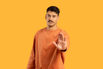 Man gesturing stop with hand on orange