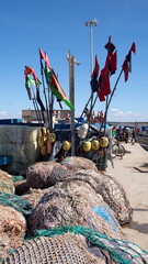 Colorful floats and flags on fishing nets on the quay, at the port in Essaouira, Morocco