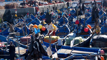 Fishing boats, with colorful floats for the fishing nets, moored in the marina at the port in Essaouira, Morocco - obrazy, fototapety, plakaty