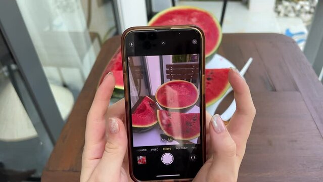  Vegan vegetarian woman female taking picture of healthy antioxidant colorful veggies, raw juice fruits for eating after market in fridge watermelon. by smartphone