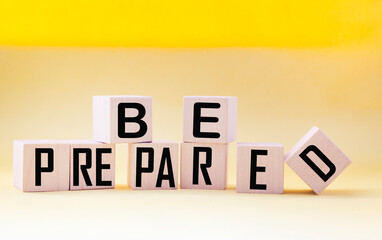 Be prepared words written on a wooden block with a yellow background. Conceptual symbol. Copy space.