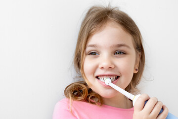 Caucasian child girl cleaning her teeth with electric toothbrush,dental concept, beautiful kid  smile.