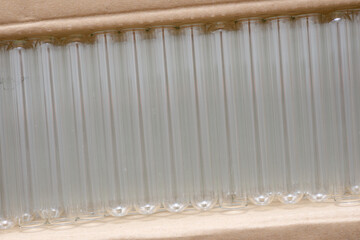 Glass test tubes stacked and sorted in a carton box