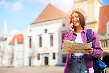 Woman with map and phone in European city