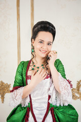 Young beautiful woman in green rococo style medieval dress