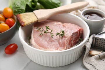 Raw meat, thyme, brush with marinade and products on light table, closeup - obrazy, fototapety, plakaty