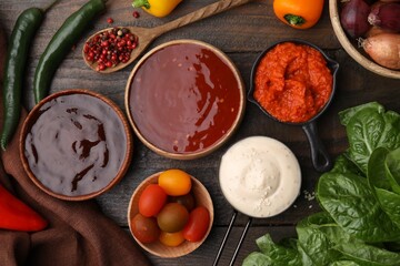 Different marinades and products on wooden table, flat lay