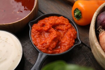 Homemade marinade in sauce pan on wooden table, closeup