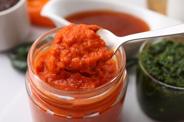 Fototapeta premium Taking homemade marinade from jar at table, closeup