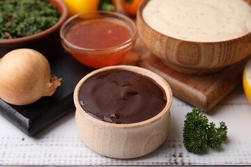 Fresh marinades in bowls and ingredients on white wooden table, closeup