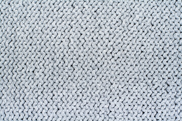 Sweater or scarf fabric texture large knitting. Knitted jersey background with a relief pattern. Wool hand- machine, handmade, gray.