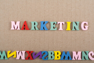 MARKETING word on wooden background composed from colorful abc alphabet block wooden letters, copy space for ad text. Learning english concept.