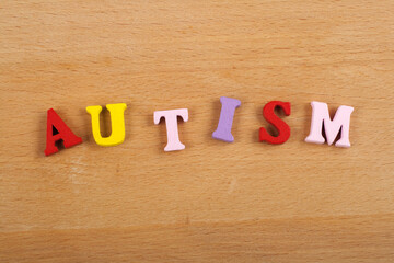 AUTISM word on wooden background composed from colorful abc alphabet block wooden letters, copy space for ad text. Learning english concept.