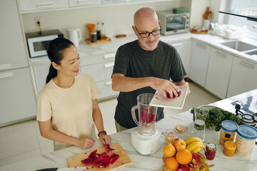 Cheerful diverse couple cooking healthy breakfast together