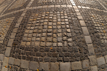 Square pavement paved with gray and brown cobblestones rectangles ornament texture