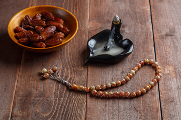 There are smoking date incense and Ramadan rosary on the table.