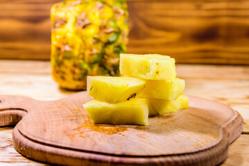 Cutting board with sliced pineapple on wooden table