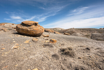 Large round red concretion on the horizon at Red Rock Coulee near Seven Persons, Alberta, Canada - obrazy, fototapety, plakaty