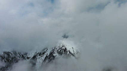 Aerial view of snowcapped mountains in clouds